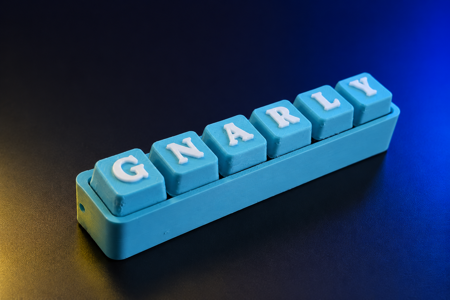 A turquoise six-key ClickClacks fidget keyboard spelling GNARLY